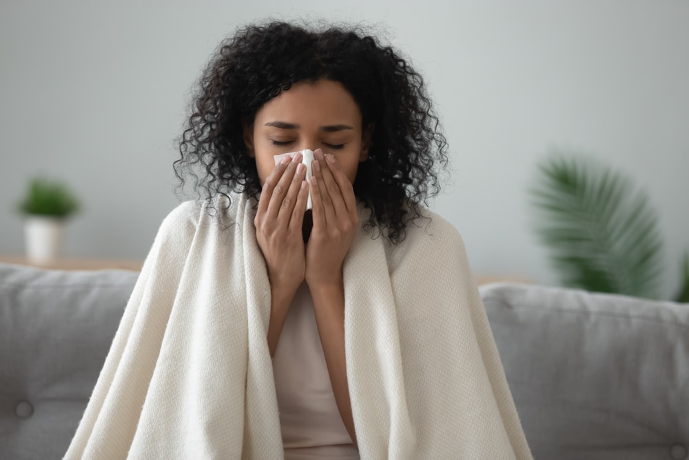 Woman under the weather on the couch with flu.