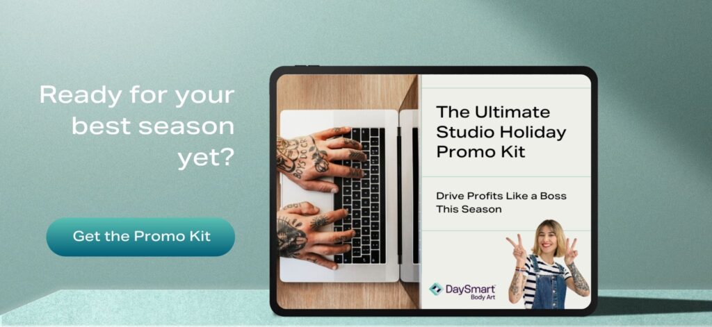 A tablet shows DaySmart Body Art's Ultimate Studio Holiday Promo Kit: Drove Profits Like a Boss This Season with the caption "Ready for your best season yet?" and a "Get the Promo Kit" download button