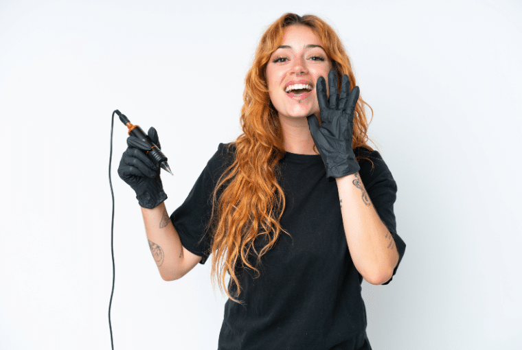 A young female tattoo artist holds a pen and shouts a message of encouragement