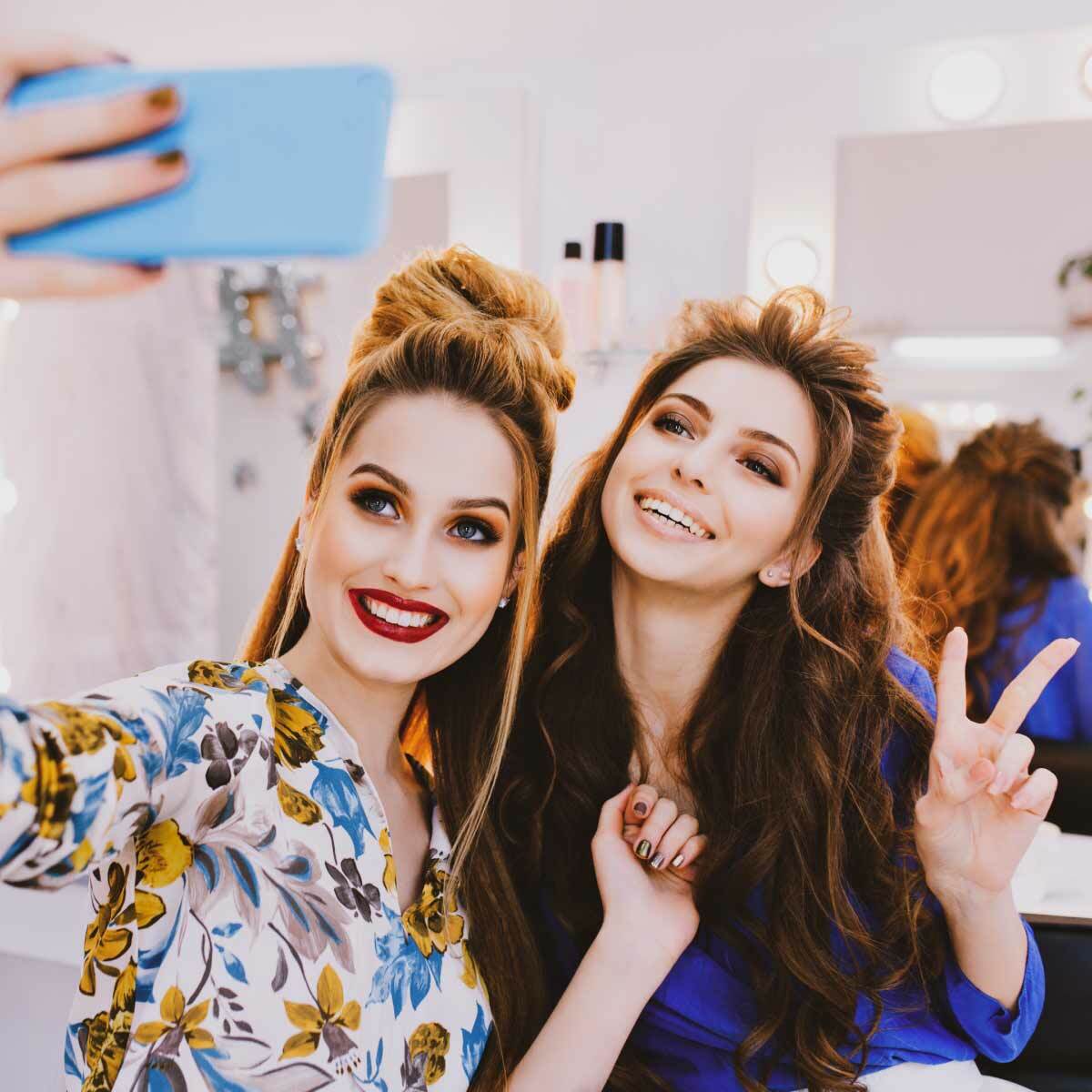 Lovable Caucasian Women In Colored Hoodies Posing With Smile On The Street  At Autmn Day. Stylish Girls Friends Laughing, Having Fun, Expressing  Positive Emotions To Camera. Stock Photo, Picture and Royalty Free