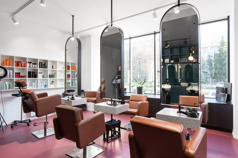 Salon with three Salon chairs and hair products lining the wall.