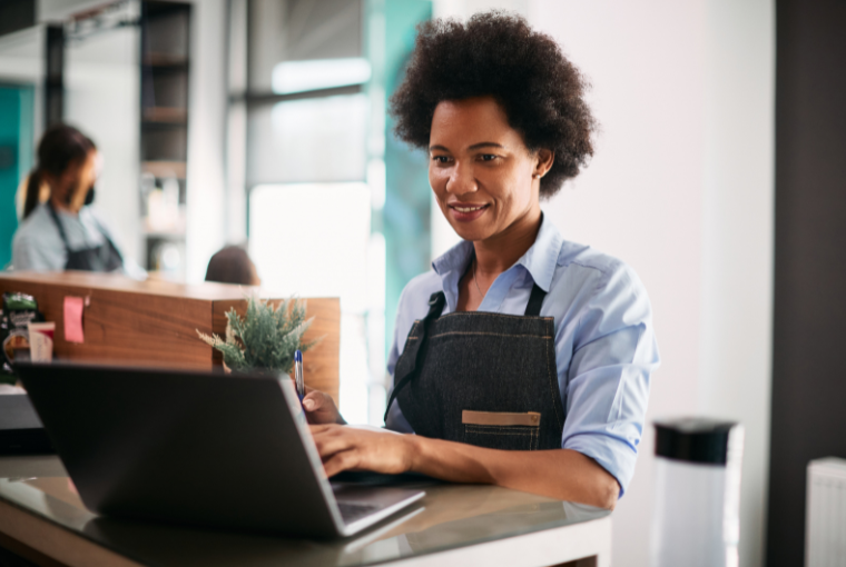 A hair stylist uses salon software at the reception desk