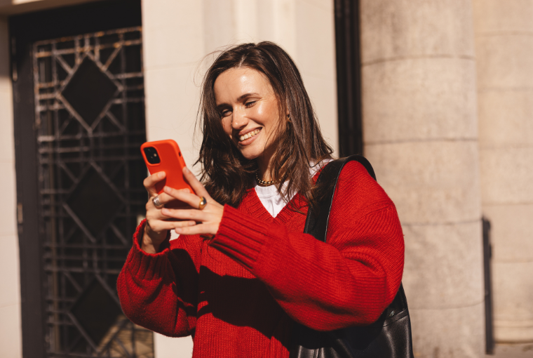 A young customer uses her mobile phone to book a hair and nail appointment on the go.
