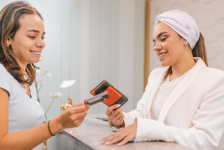 A satisfied customer pays for her latest treatment at the spa