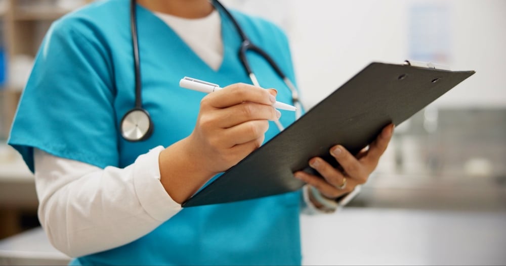 A veterinary professional reviews a clipboard.