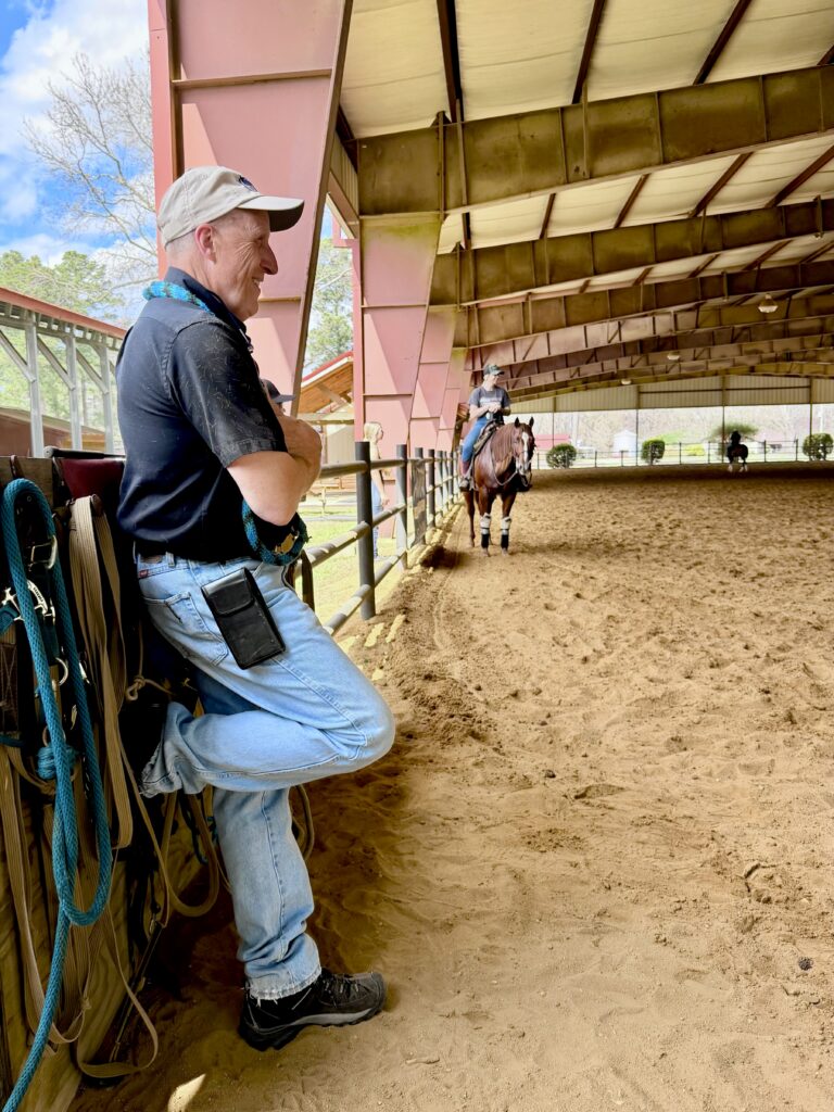 Equine veterinarian Dr. Meyer observing a horse during a lameness evaluation in a covered riding arena