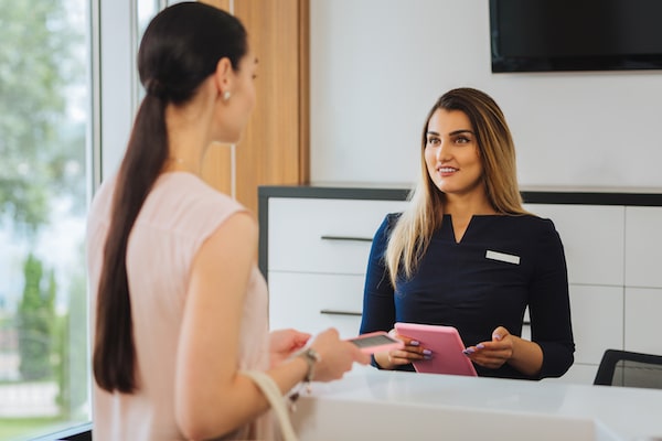 Staff member at a business helping someone check in